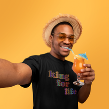 Load image into Gallery viewer, man wearing a black 'king for life' short sleeve unisex t-shirt while sipping a cocktail.