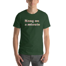 Load image into Gallery viewer, a model wearing a forest green t-shirt with the caption 'hang on a minute' written in pearlescent letters