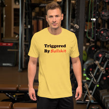 Load image into Gallery viewer, yellow t-shirt with caption 'triggered by bullshit' in black and green lettering