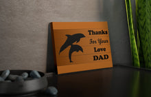 Load image into Gallery viewer, brown canvas tile with silhouette of dolphin and calf and the caption &quot;thanks for your love dad&quot;
