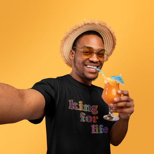 man wearing a black 'king for life' short sleeve unisex t-shirt while sipping a cocktail.