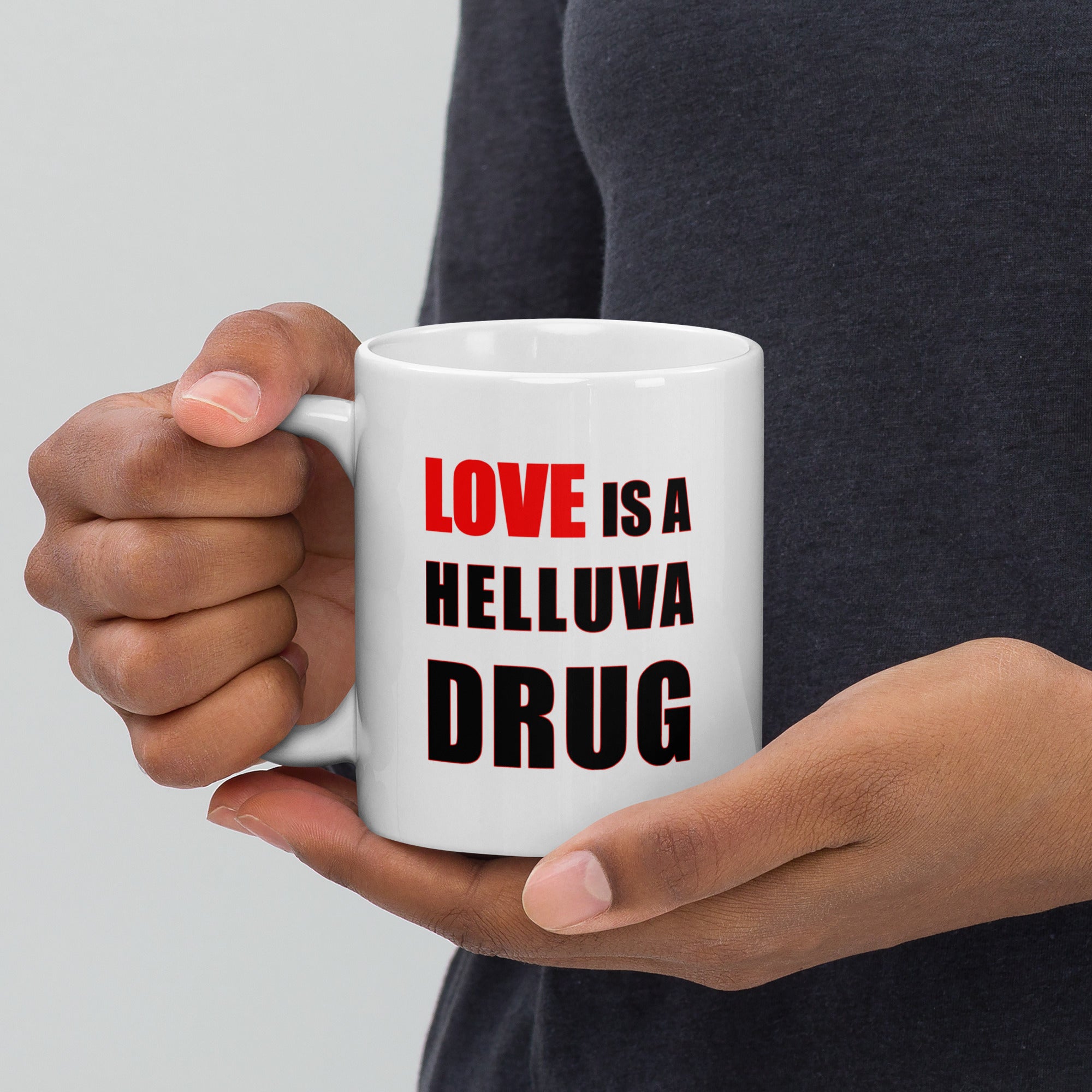 11oz white ceramic mug with the caption 'love is a helluva drug' in black and red letters