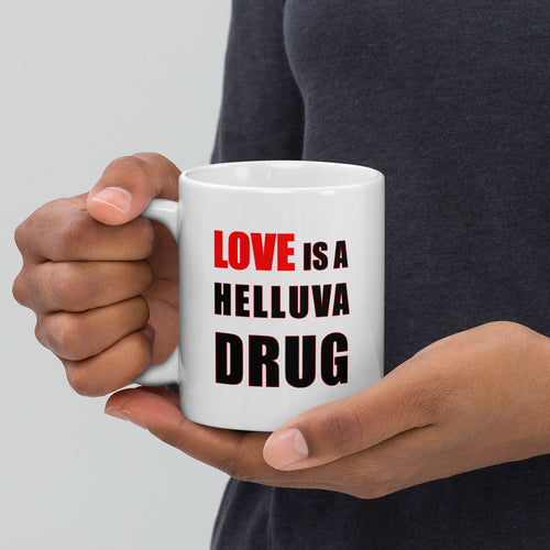 11oz white ceramic mug with the caption 'love is a helluva drug' in black and red letters