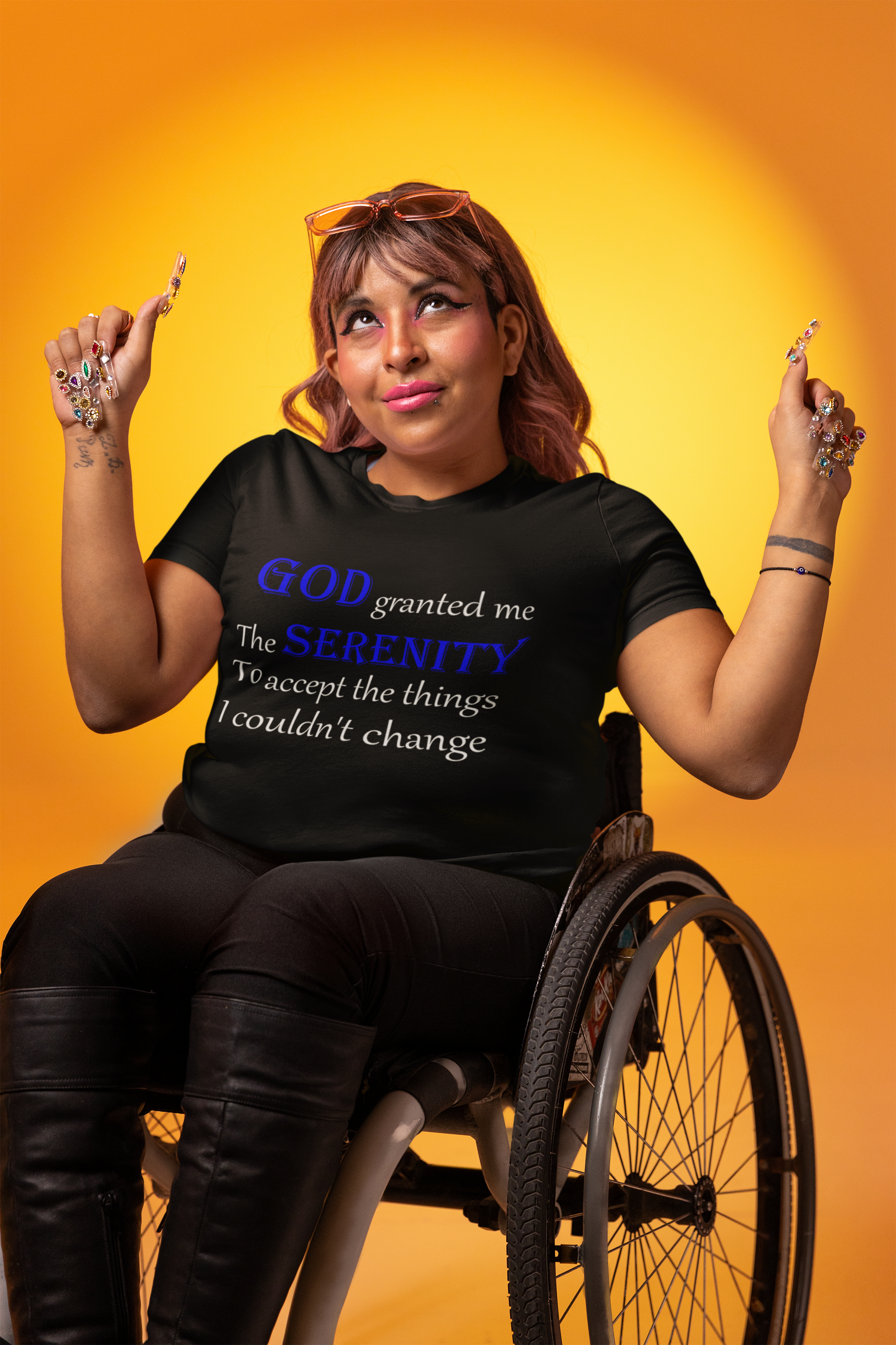 woman sitting in a wheelchair wearing a black t-shirt stating God granted me the serenity to accept the things I couldn't change