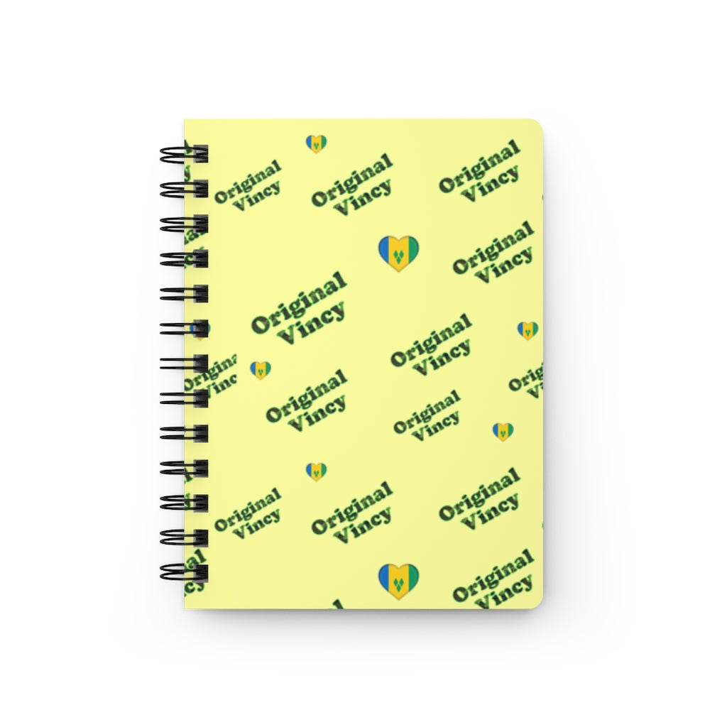 Yellow spiral notebook/journal with 'original vincy' written in camouflage green with hearts containing the St. Vincent and the Grenadines flag.