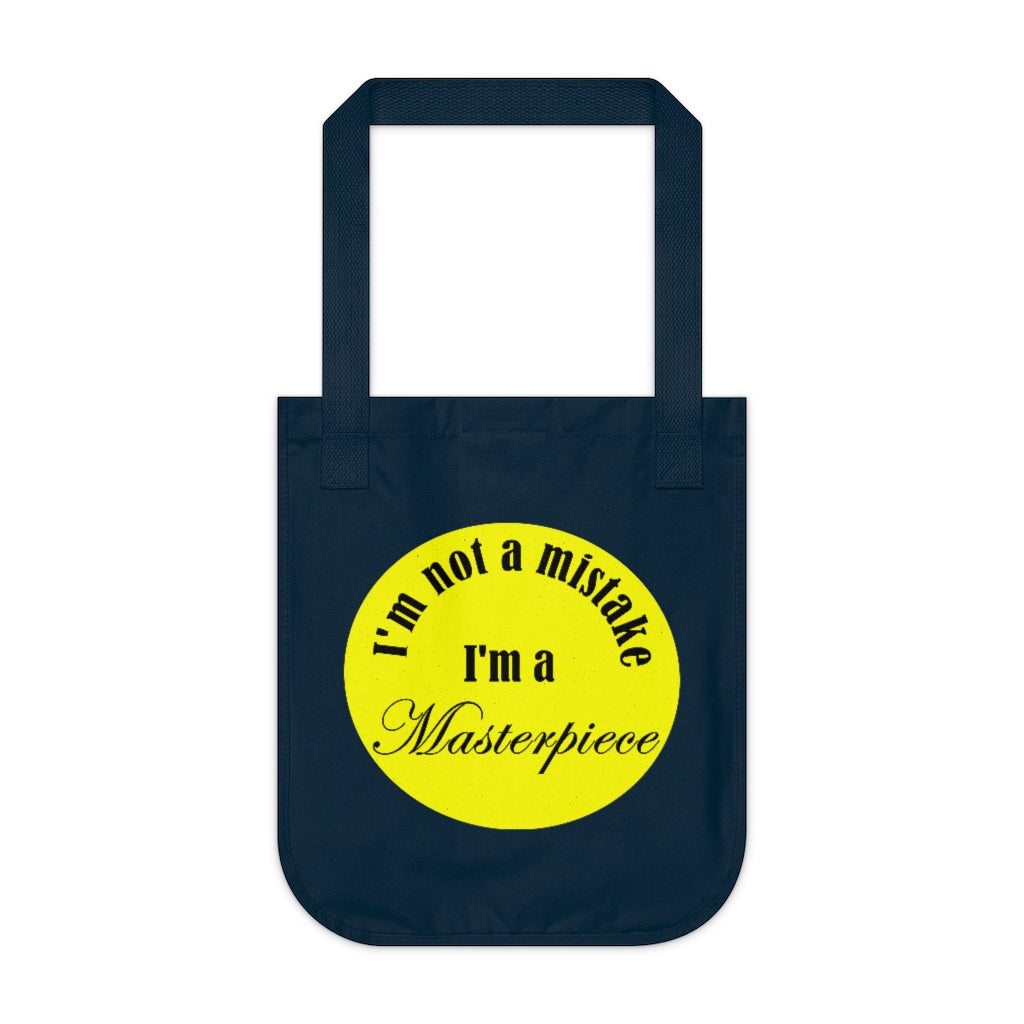 navy blue eco-friendly organic canvas tote bag with a yellow circle stating 'I'm not a mistake I'm a masterpiece'