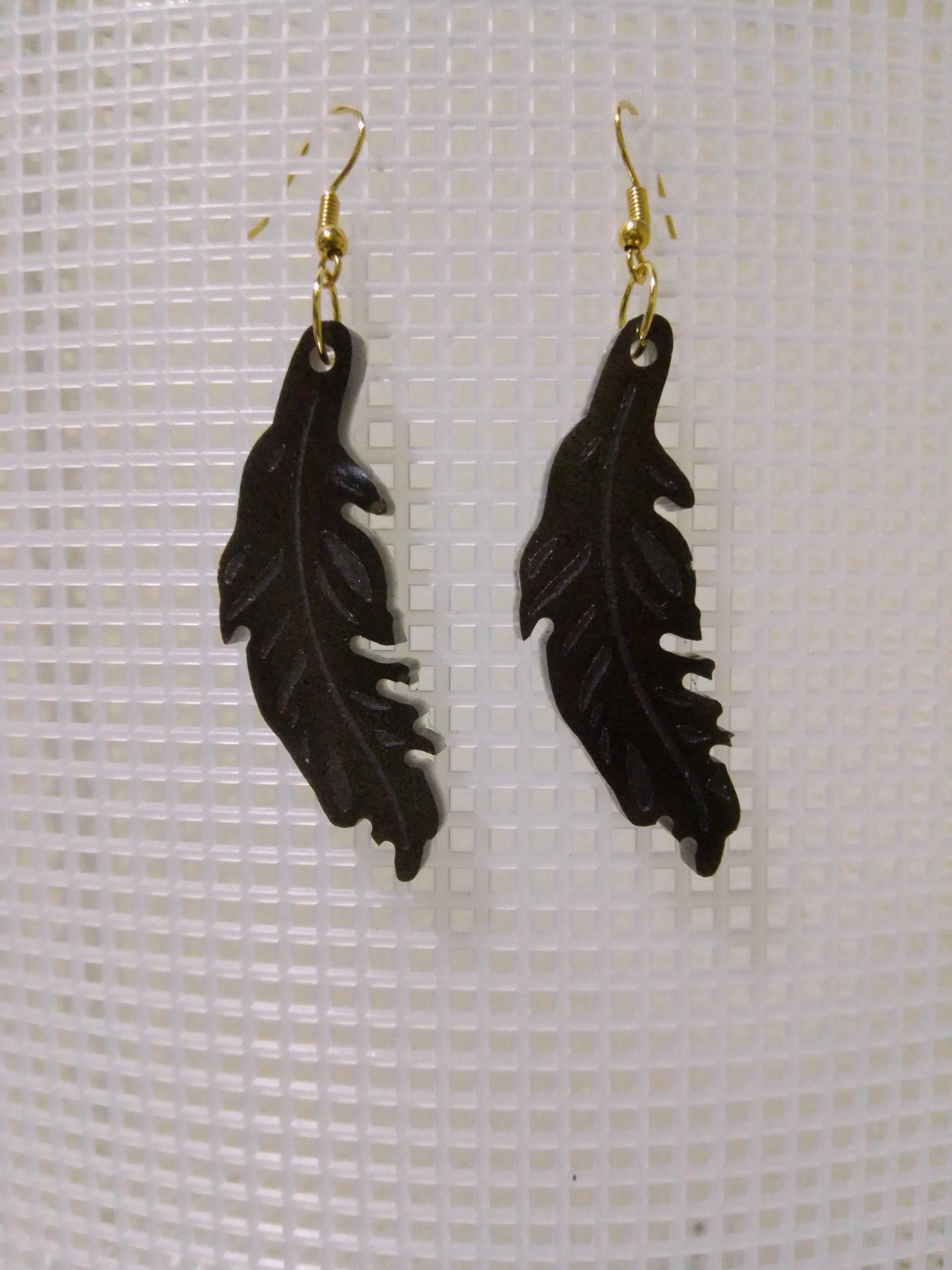 volcanic ash and epoxy resin earrings shaped like a feather