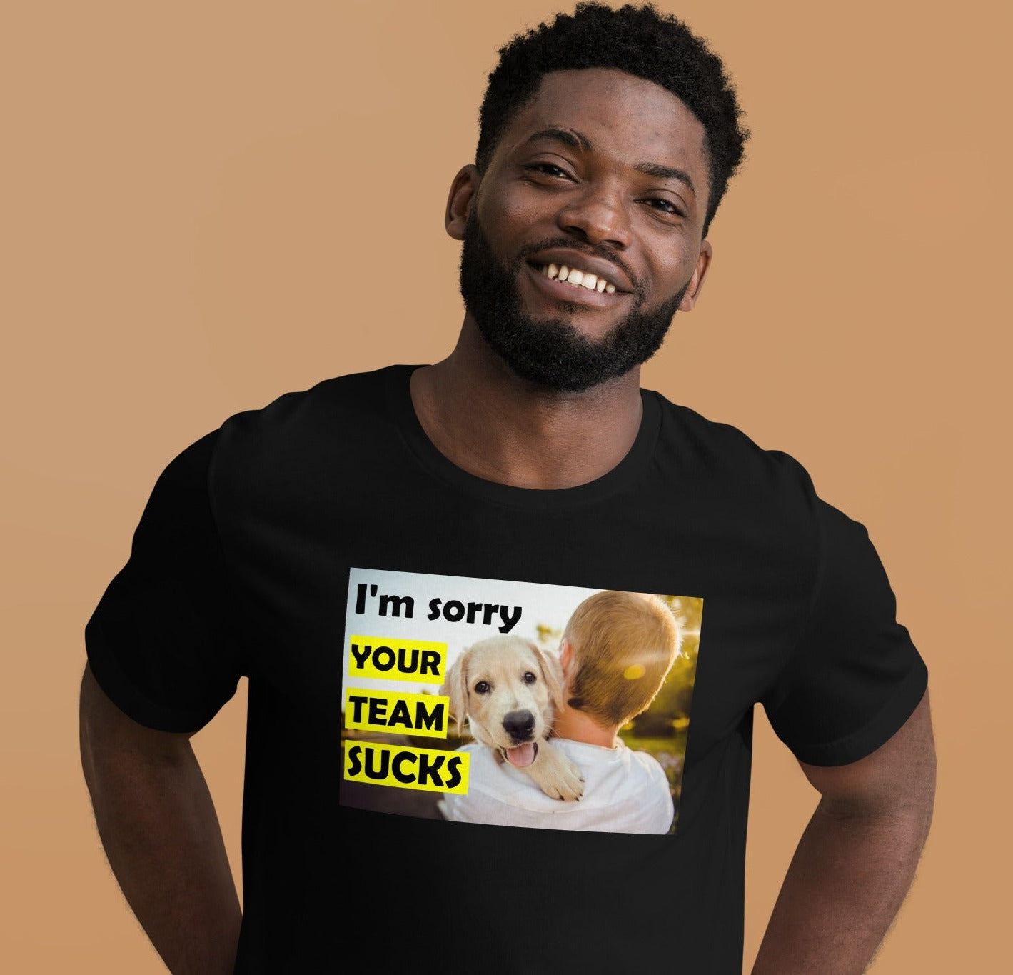 man wearing a black t-shirt showing a puppy looking over a his back with the caption 'i'm sorry your team sucks'.