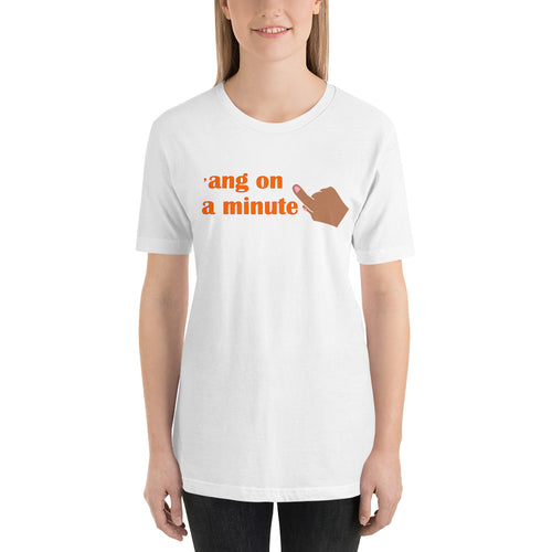model wearing a white 'ang on a minute t-shirt' in orange letters and with a raised index finger