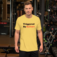 Load image into Gallery viewer, yellow t-shirt with caption &#39;triggered by bullshit&#39; in black and green lettering
