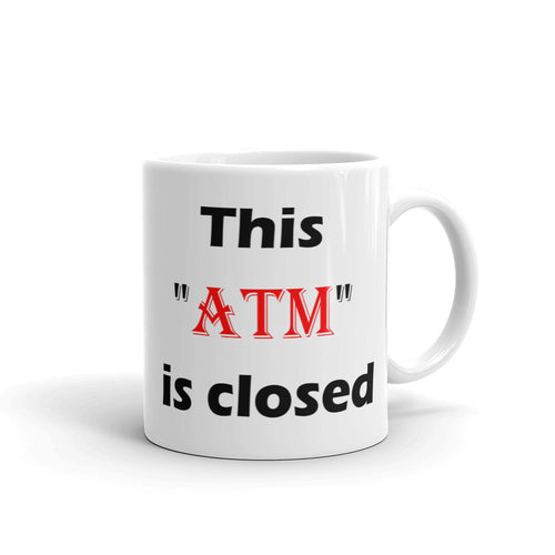 White glossy ceramic coffee mug stating 'this atm is closed' in black and red letters.